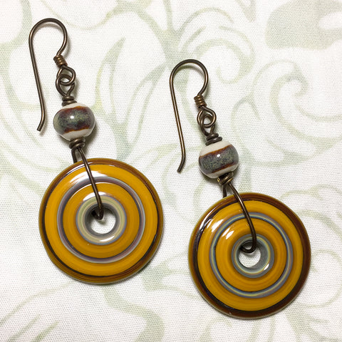 Antiqued brass and niobium earrings with orange art glass discs and earthtone art ceramic beads