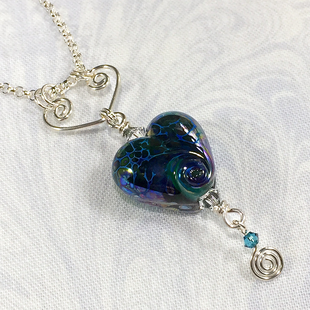 Sterling necklace with iridescent blue art glass heart bead on a handmade heart-shaped pendant
